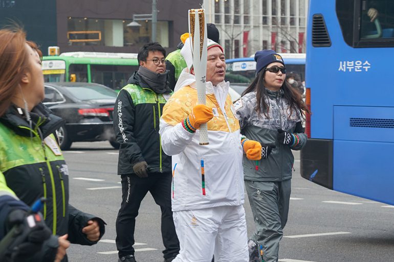 Kim walks through the streets of Seoul with the Olympic flame. 