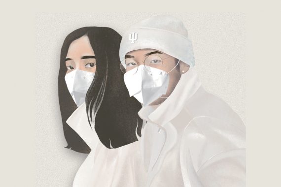 Two people with dark hair wearing all-white clothing, including white face masks, stand close together and look forward. The person on the right wears a white beanie with an IU trident on it.