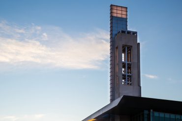 A wide-shot photo of the IUPUI bell tower picutured against a blue sky.
